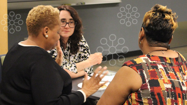 Faculty discussing around a table